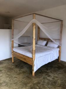 姆托瓦姆布Jua Manyara Lodge & Camp Site的一间卧室配有一张木床和天篷