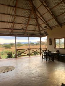 姆托瓦姆布Jua Manyara Lodge & Camp Site的配有桌椅并享有田野景致的客房