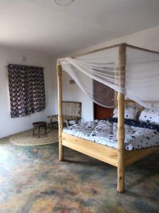 姆托瓦姆布Jua Manyara Lodge & Camp Site的一间卧室配有一张木床和天篷