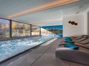 辛特利斯哈斯霍夫泽博斯特酒店的一个带窗户的房间,设有一个游泳池,配有沙发