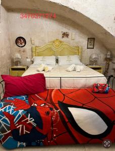 法萨诺Palazzo Savoia 1856的一间卧室配有一张大床和蜘蛛人毛毯