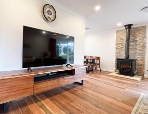 黑荒地Birdwood Guesthouse的一间带电视和壁炉的客厅