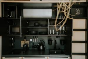 鲍洛通塞派兹德Slowood Cabins的黑色厨房配有水槽和微波炉