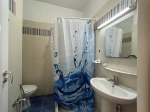 拉马萨Palmeraies vacances Tunis的浴室设有蓝色和白色的浴帘和水槽