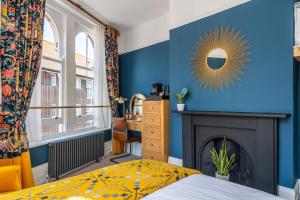 惠茨特布尔Duke of Cumberland的一间卧室设有蓝色墙壁、壁炉和镜子