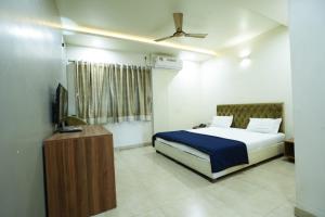 戈尔哈布尔Hotel Anand的一间卧室配有一张床和一台电视
