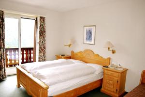 圣莫里茨Hotel Salastrains的卧室配有一张白色大床和电话