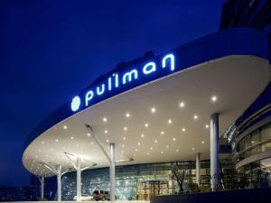 伊斯坦布尔Pullman Istanbul Hotel & Convention Center的一座建筑物,上面有夜间标志