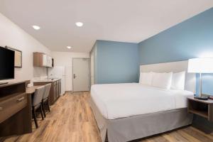 萨凡纳WoodSpring Suites Savannah Pooler的酒店客房设有一张大床和一个厨房。
