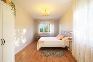 MorteraVilla La Palmera的一间卧室设有一张床、一个窗户和一个吊灯。