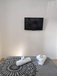 瓦伦西亚Apartamento delux2的卧室配有2条毛巾和1张带1台平面电视的床