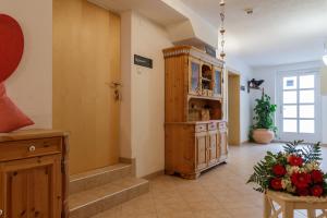 上蒂利拉赫Apartments Gannerhof的走廊上设有木柜和鲜花桌