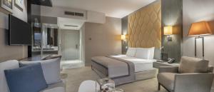 凯里尼亚Elexus Hotel Resort & Spa & Casino的配有一张床和一把椅子的酒店客房