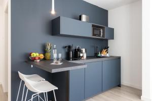 比勒费尔德zzzpace Smart-Hotel Bielefeld Zentrum的厨房设有蓝墙和台面