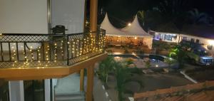 恩德培Mowicribs Hotel and Spa的享有带灯光和游泳池的阳台的顶部景色