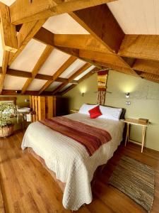 涅夫拉Cabañas Fischer SpA的一间带一张大床的卧室,位于一个拥有木制天花板的房间