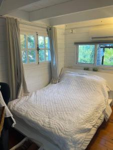 梅图拉בקתות עץ סקנדינביות במטולה的卧室配有白色床和2扇窗户