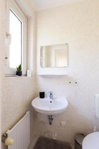 汉诺威Perle am Maschsee. Ein Haus mit Garten und 4 Zimmern的白色的浴室设有水槽和镜子