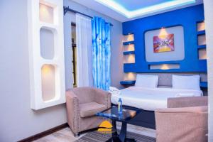 阿西里弗Galaxy Resort Kitengela的一间卧室配有一张床、一把椅子和一张桌子