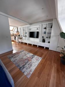伦敦Studio flat in the heart of Hampstead, London的客厅设有大电视和硬木地板。