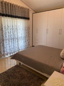 Rooms for rent Gezim Ismailaj的一间卧室设有一张床和一个大窗户