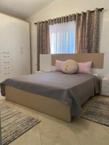 Rooms for rent Gezim Ismailaj的一间卧室配有带粉红色枕头的床和窗户。