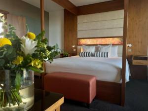 邓多克The Gateway Hotel的配有一张床和花瓶的酒店客房