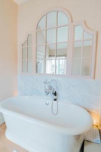 Newbold on Stour法兹达克酒店的浴室设有白色浴缸及镜子