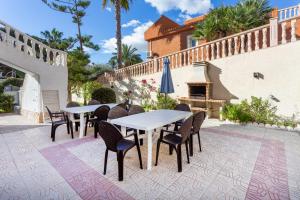 弗拉门卡海滩5 bedroom Villa private pool的一个带桌椅和壁炉的庭院