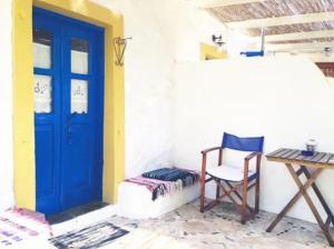 ArkoiKaiti’s House的一间设有蓝色门、椅子和桌子的房间