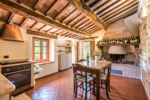 卡斯蒂戈隆·多尔希亚Appartamento Gemma Bianca-tavoleto的厨房配有木桌和壁炉。