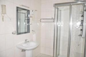 基加利Hotel Karisimbi的白色的浴室设有水槽和淋浴。