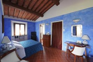 卡斯泰尔菲奥伦蒂诺Locanda le Boscarecce的一间卧室设有蓝色的墙壁、一张床和一张书桌
