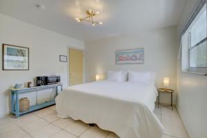 劳德代尔堡LoKal Rental Tropical Florida destination的白色卧室配有大床和微波炉
