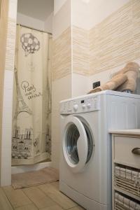 瓦雷泽Cimoneight的洗衣房配有带浴帘的洗衣机