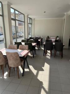 埃迪尔内Maritsa Hotel的用餐室设有桌椅和窗户。