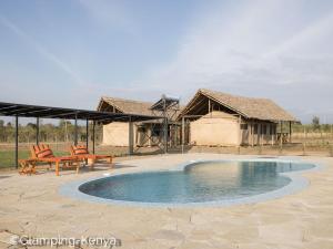 Naro MoruGlamping Kenya Mt. Kenya Lodge的一个带游泳池、两把椅子和帐篷的度假村