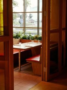 巴统Rooms Hotel Batumi的植物窗前的桌子
