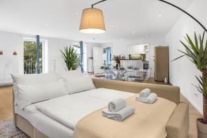 慕尼黑PRIME - City Apartment für 6 - Neu & Modern的客厅配有一张沙发,桌子上配有毛巾