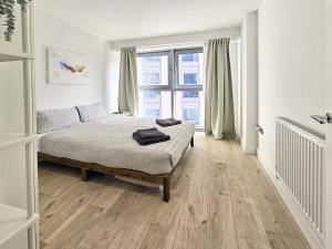 伦敦Beautiful 2 bedroom flat in Battersea的一间卧室设有一张床和一个大窗户