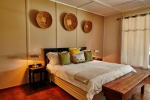 纳姆比提动物保护区Cheetah Ridge Lodge的卧室配有一张床和墙上的2个盘子