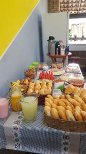 阿拉亚尔-杜卡布Hostel Caminho da Praia的桌子上放着一篮面包和其他食物