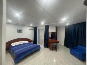 苏塞Residence ElFaracha的一间卧室配有一张床、一张桌子和一把蓝椅