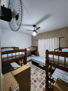阿拉亚尔-杜卡布Hostel Caminho da Praia的客房设有四张双层床和风扇。