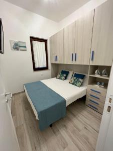 圣维托罗卡波Ca San Vito Lo Capo Villa Maria的一间卧室设有一张大床,铺有木地板。