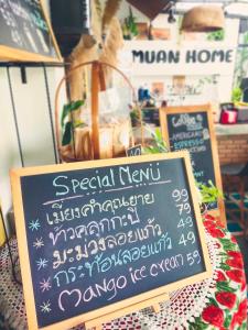 Ban Donม่วนโฮม muan home café&stay的一张桌子上的黑板标牌,上面有菜单