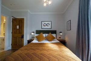伦敦THE KNIGHT OF NOTTINGHILL的一间卧室配有一张带橙色枕头的大床