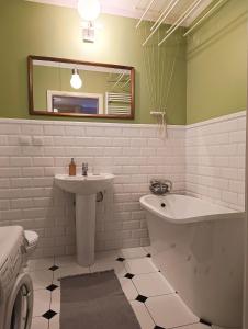 沃姆扎Apartament Parkowy 24h的一间带水槽、浴缸和镜子的浴室