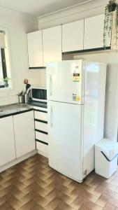 布里斯班Guesthouse in fantastic location的厨房配有白色橱柜和白色冰箱。