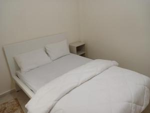 卡萨布兰卡Chambre privative dans un appartement partagé的白色的床、白色床单和枕头